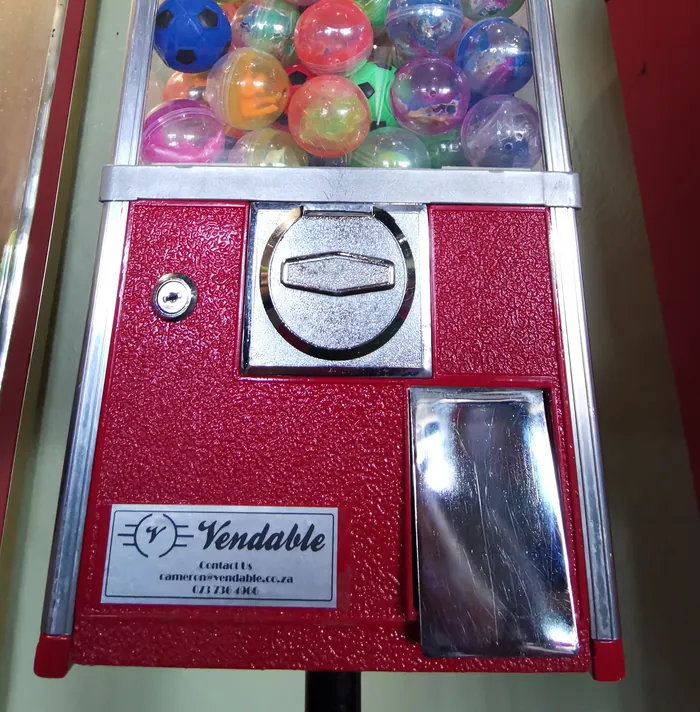 Close-up of a Vendable capsule machine showing the R5 coin slot and the Vendable owner's plate